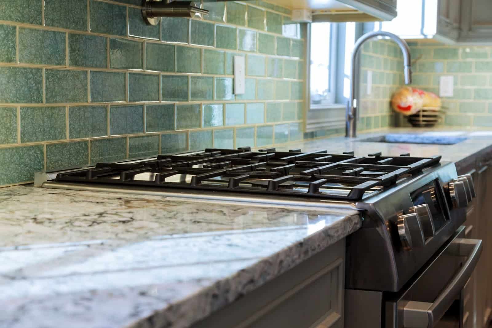 High-quality green tile backsplash in modern kitchen setting.